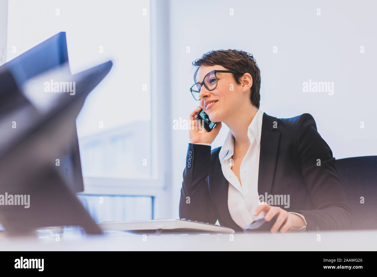 Junge geschäftsfrau am Telefon am Schreibtisch im Büro Stockfoto