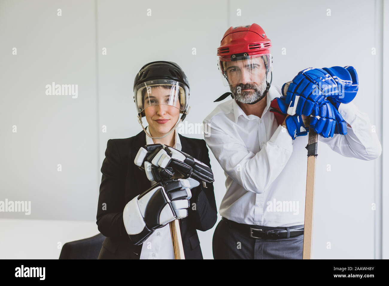 Portrait der Unternehmerin und Unternehmer tragen Eishockey Ausrüstung im Büro Stockfoto
