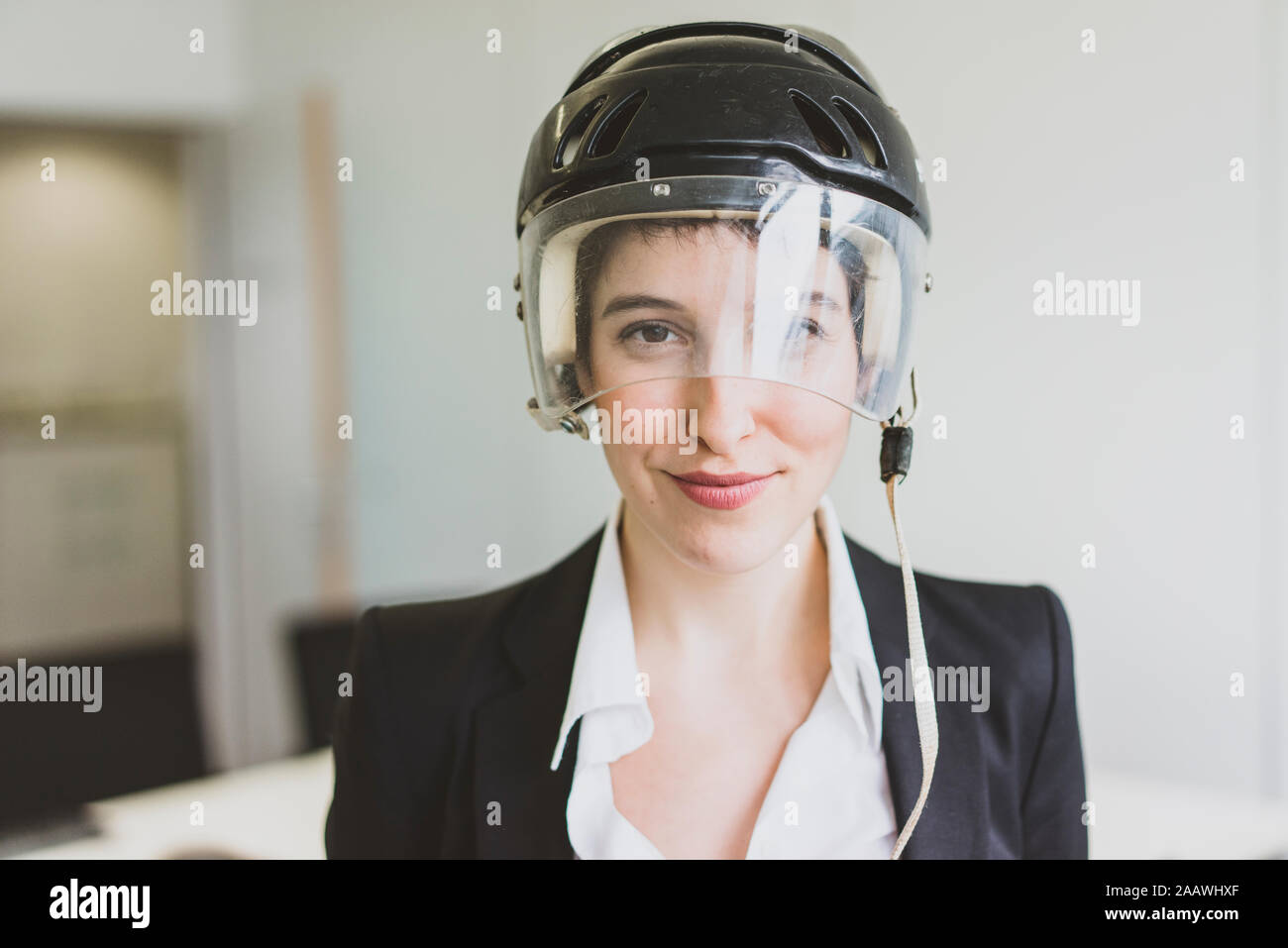 Portrait von selbstbewussten jungen Geschäftsfrau tragen Eishockey Helm im Büro Stockfoto