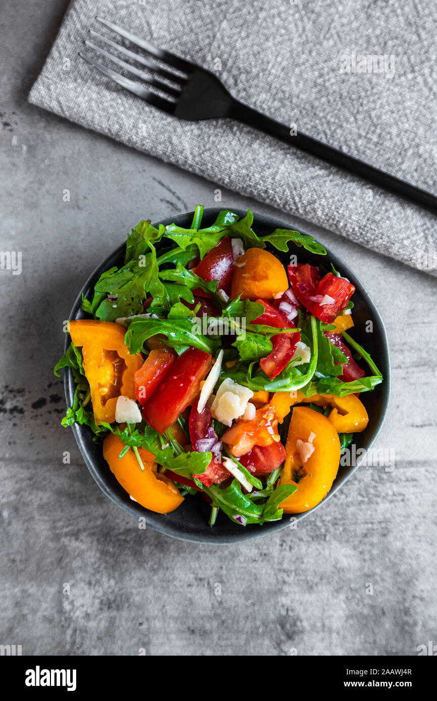 Schüssel Salat mit roten und gelben Tomaten, Rucola und Parmesan Stockfoto