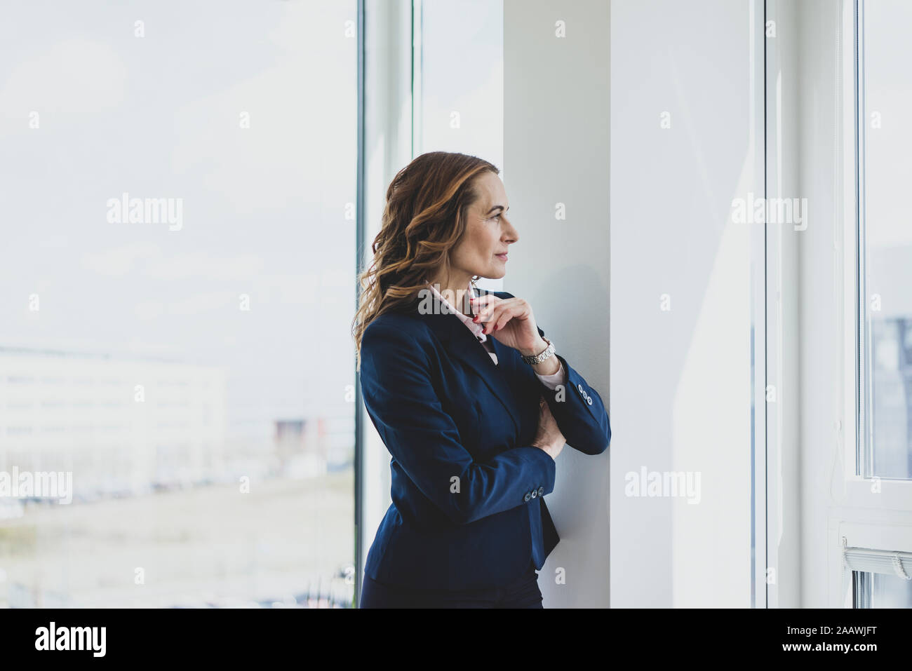 Reife Geschäftsfrau Blick aus Fenster im Büro Stockfoto