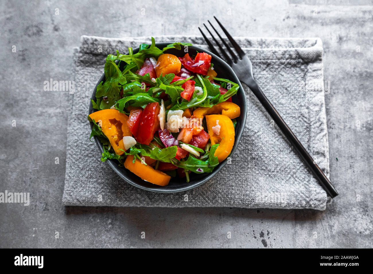 Schüssel Salat mit roten und gelben Tomaten, Rucola und Parmesan Stockfoto