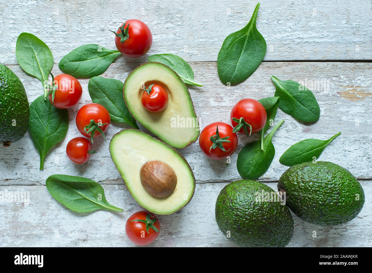 Direkt oberhalb der Schuß von Avocados mit Tomaten und Spinat auf hölzernen Tisch Stockfoto