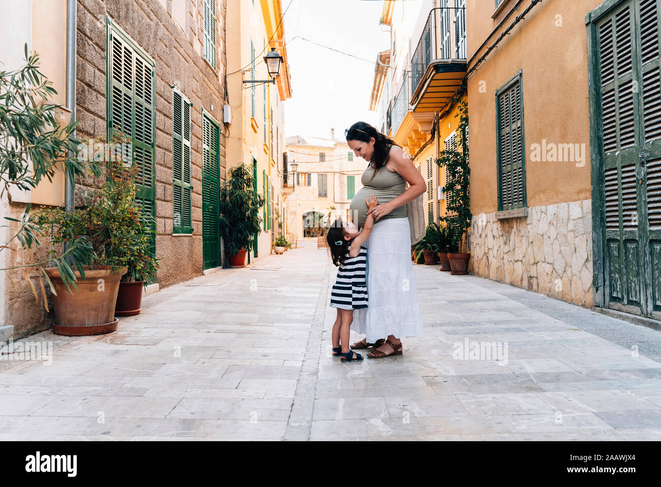 Kleines Mädchen baby Bauch der Mutter zu berühren, Alcudia, Mallorca, Spanien Stockfoto