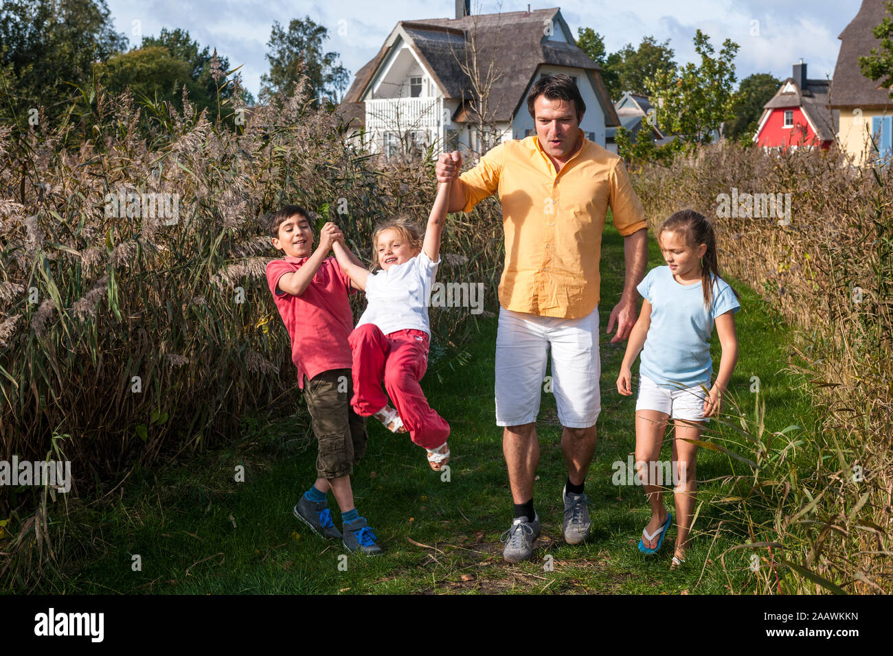 Vater mit drei Kinder gehen auf eine ländliche Weg, Darß, Mecklenburg-Vorpommern, Deutschland Stockfoto