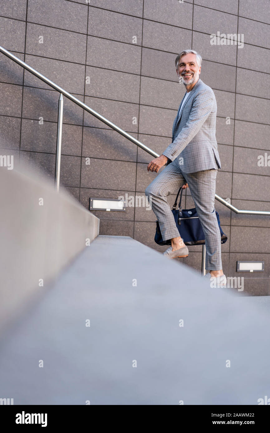 Modische Reifen Geschäftsmann mit Tasche die Treppen zu Fuß Stockfoto