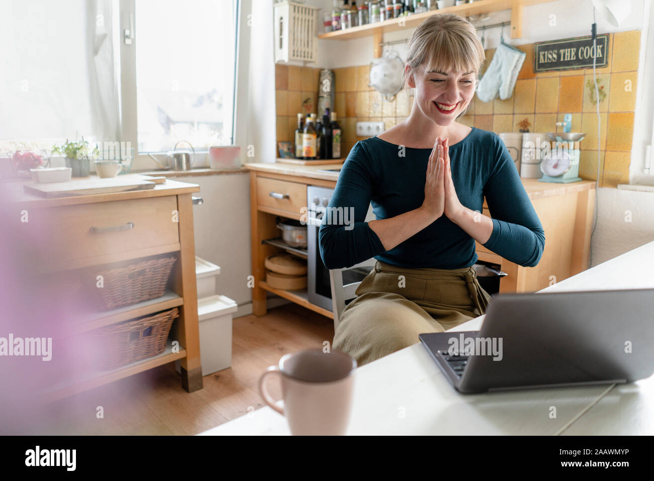 Portrait von lachende Frau mit Laptop Yoga in der Küche Stockfoto