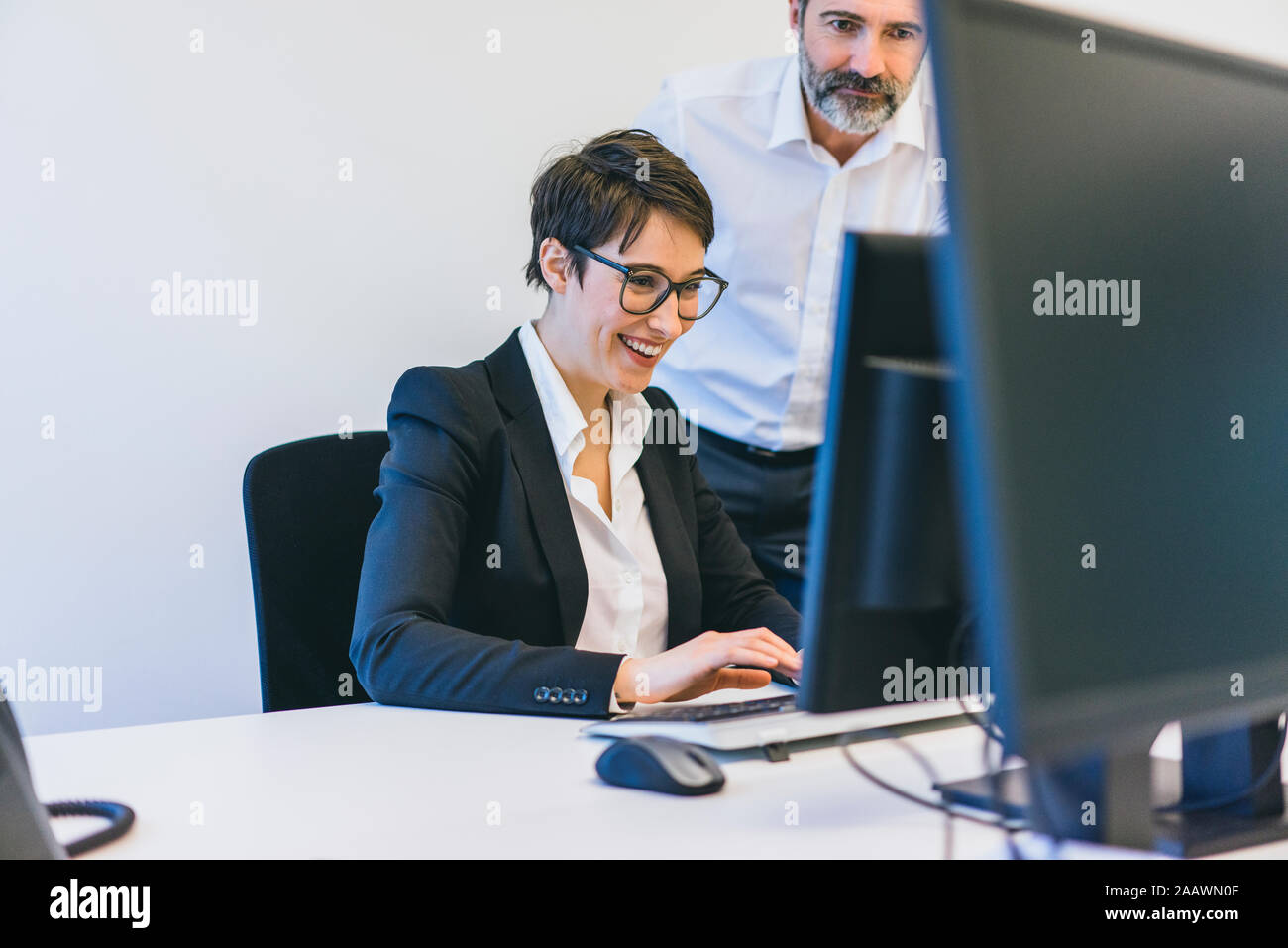 Unternehmer und Mitarbeiter am Schreibtisch im Büro Stockfoto