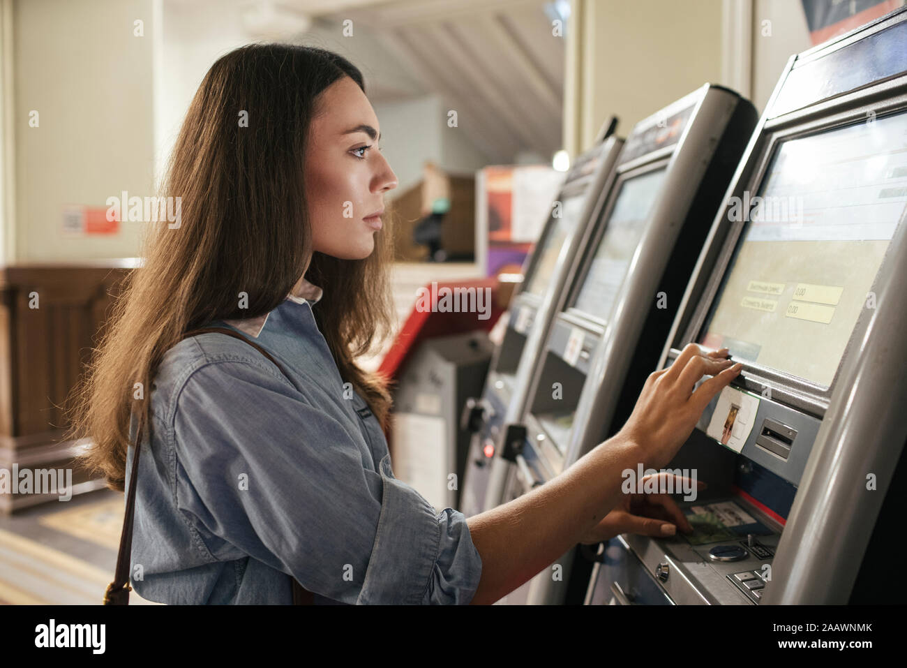 Junge weibliche Reisende kaufen Ticket von automatisierten Maschine am Bahnhof Stockfoto