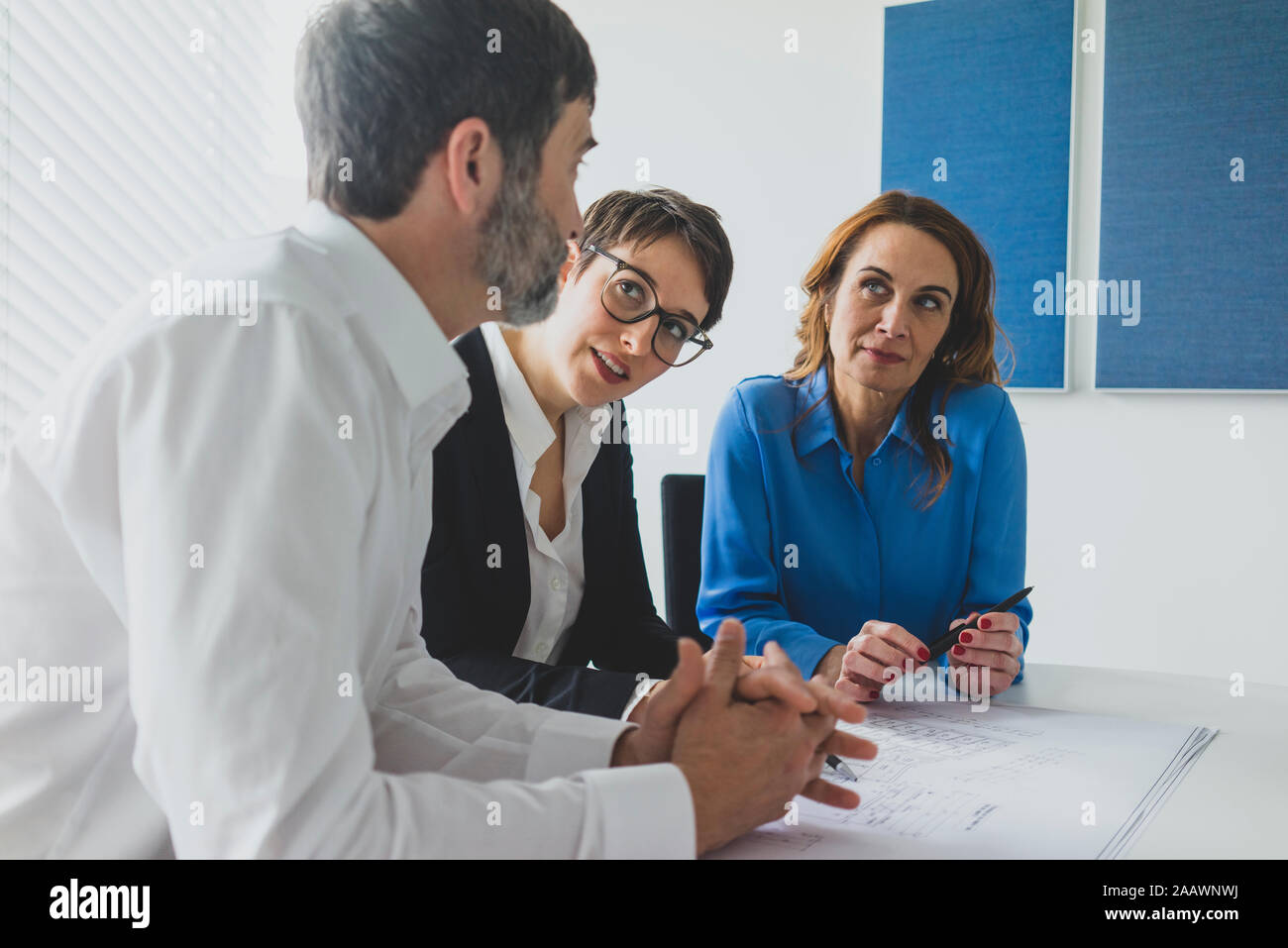 Geschäftsmann und zwei Unternehmerinnen Arbeiten am Plan auf dem Schreibtisch im Büro Stockfoto