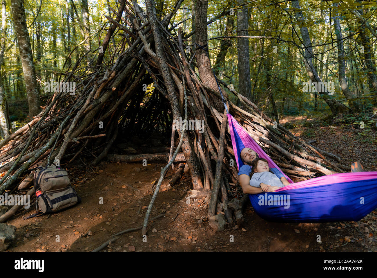 Vater und Tochter zusammen in der Hängematte liegend in einem Wald Stockfoto