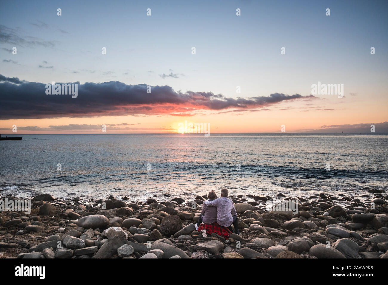 Paar und lieben Konzept mit alten Menschen umarmen und genießen Sie den herrlichen Sonnenuntergang am Strand - elerly Urlaub und Freizeit im freien Menschen - Farbe Stockfoto