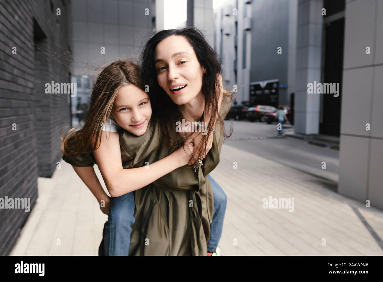 Porträt der Mutter, die ihre Tochter ein piggyback Ride Stockfoto