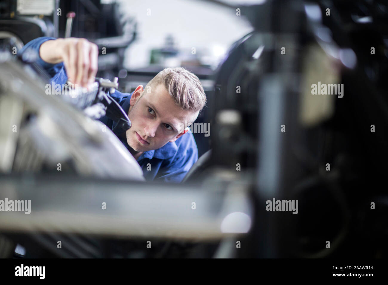 Junger Mann die Einstellung einer Maschine in einer Druckerei Stockfoto
