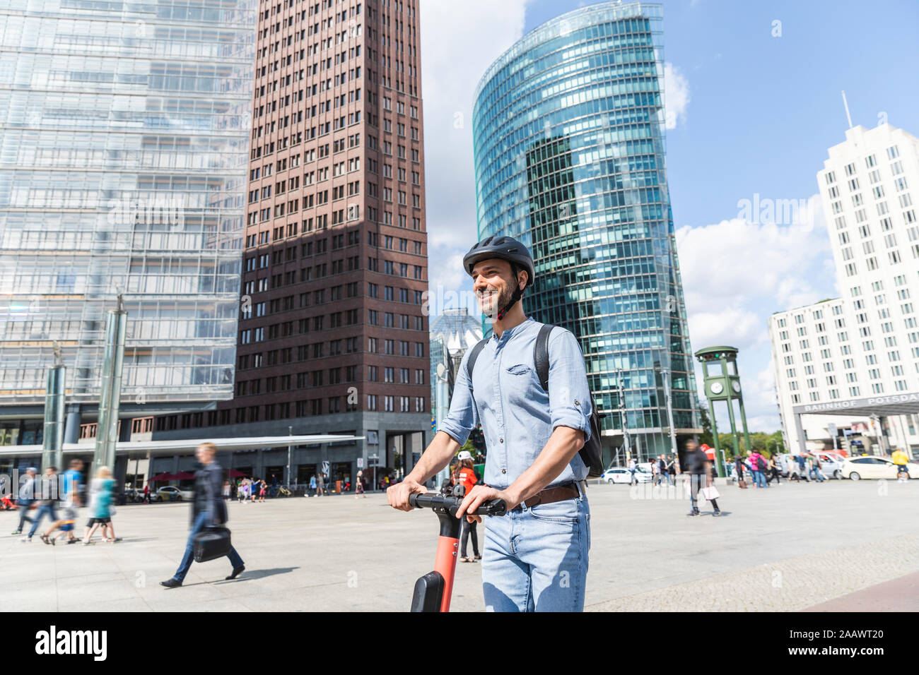 Geschäftsmann mit e-Scooter auf Platz der Stadt, Berlin, Deutschland Stockfoto