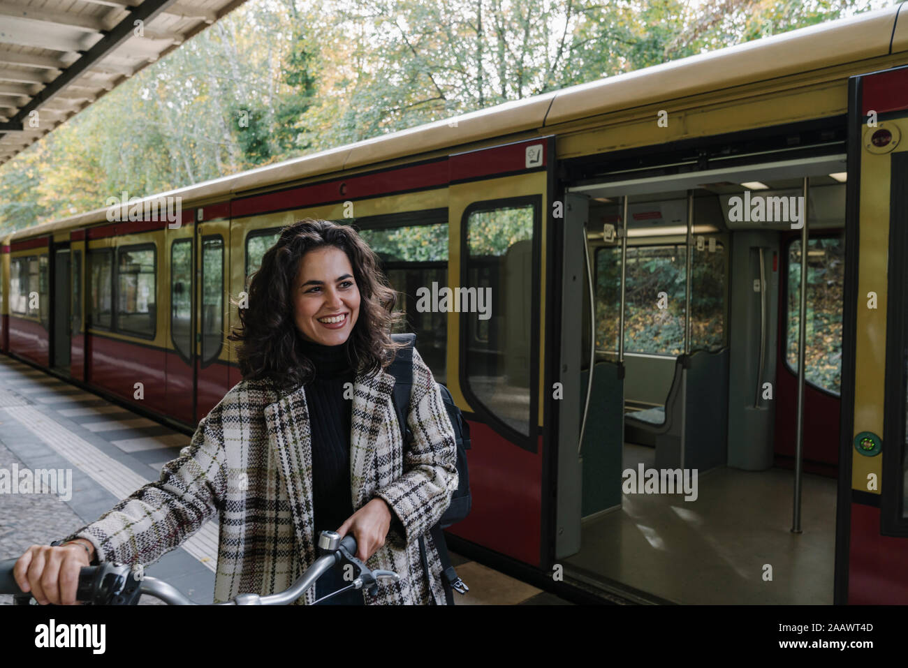 Glückliche Frau mit Fahrrad auf einem U-Bahnhof Plattform, Berlin, Deutschland Stockfoto