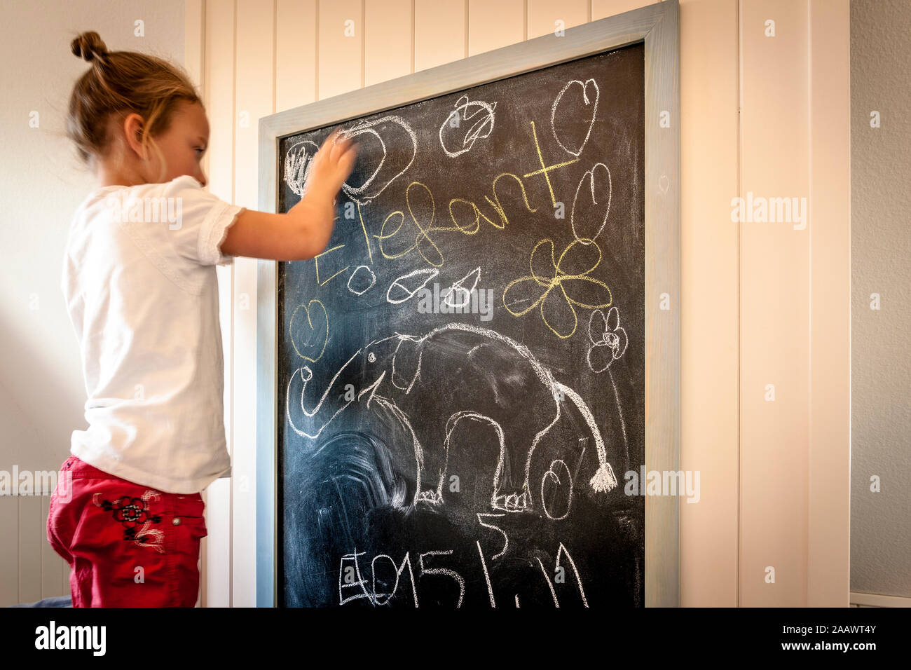Kleines Mädchen auf Tafel zeichnen Stockfoto