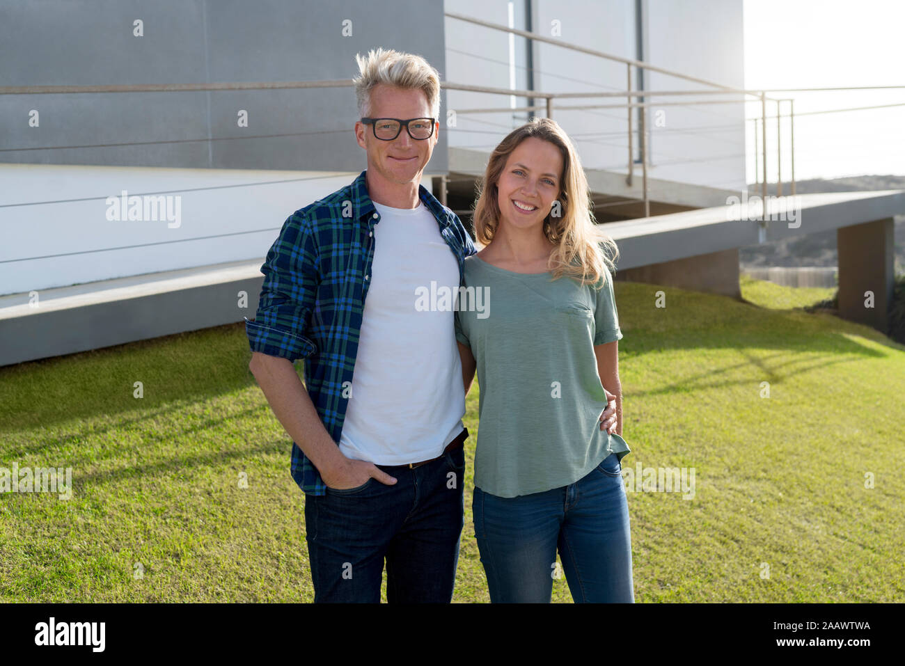 Portrait von lächelnden Paar stand vor Ihrer modernen Home Stockfoto