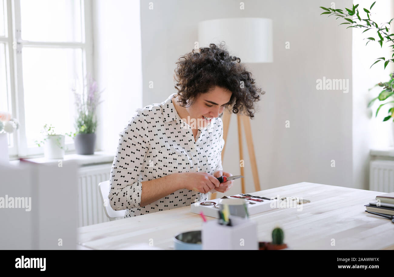 Lächelnde junge Frau am Tisch arbeiten Stockfoto