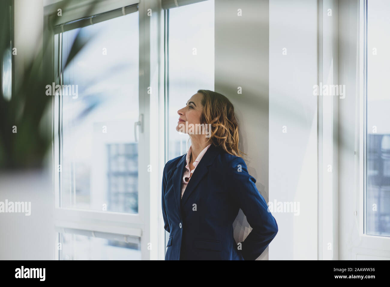 Reife Geschäftsfrau mit einer Unterbrechung am Fenster im Büro Stockfoto