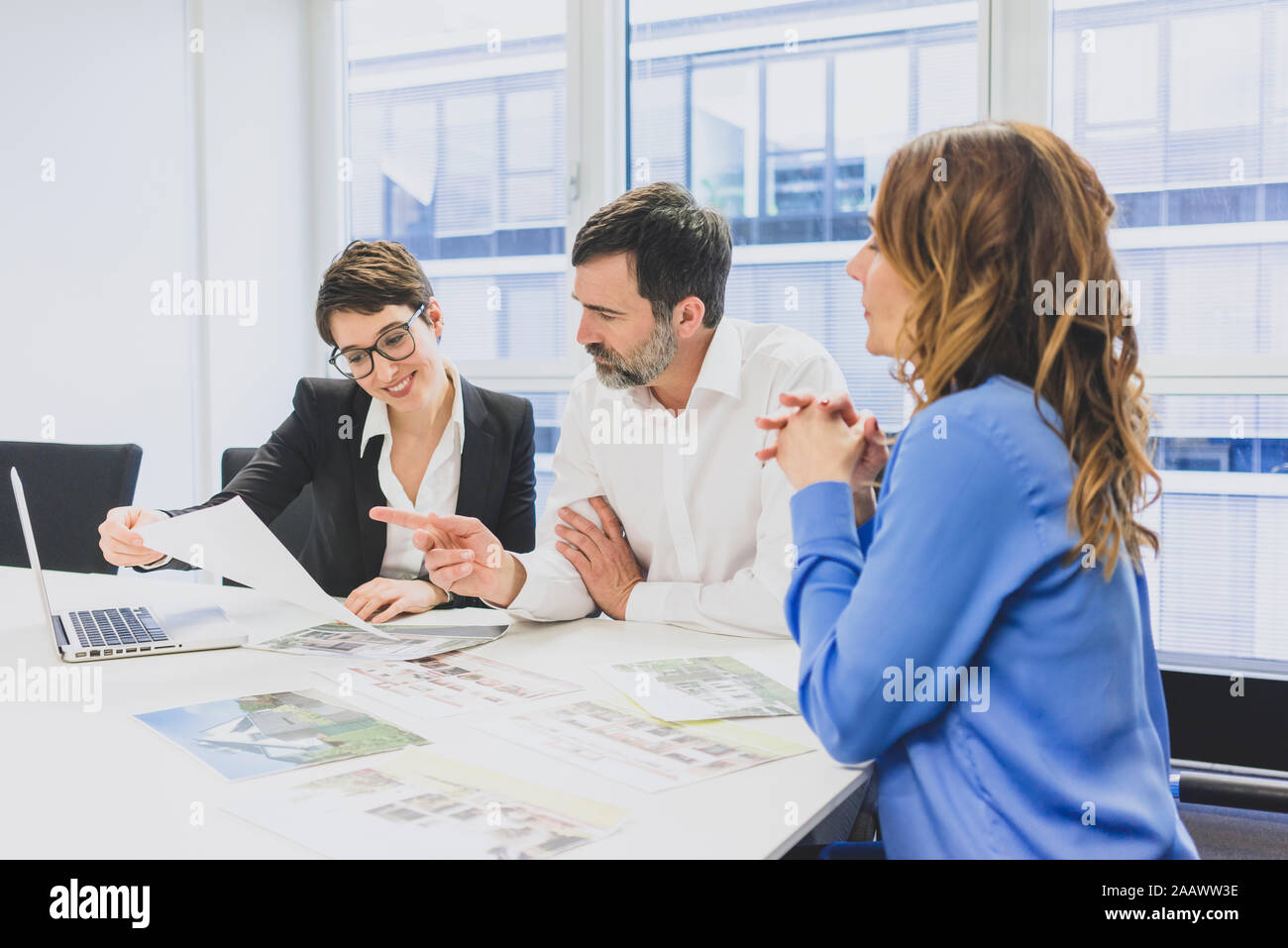 Geschäftsmann und zwei Unternehmerinnen zusammen arbeiten am Schreibtisch im Büro Stockfoto