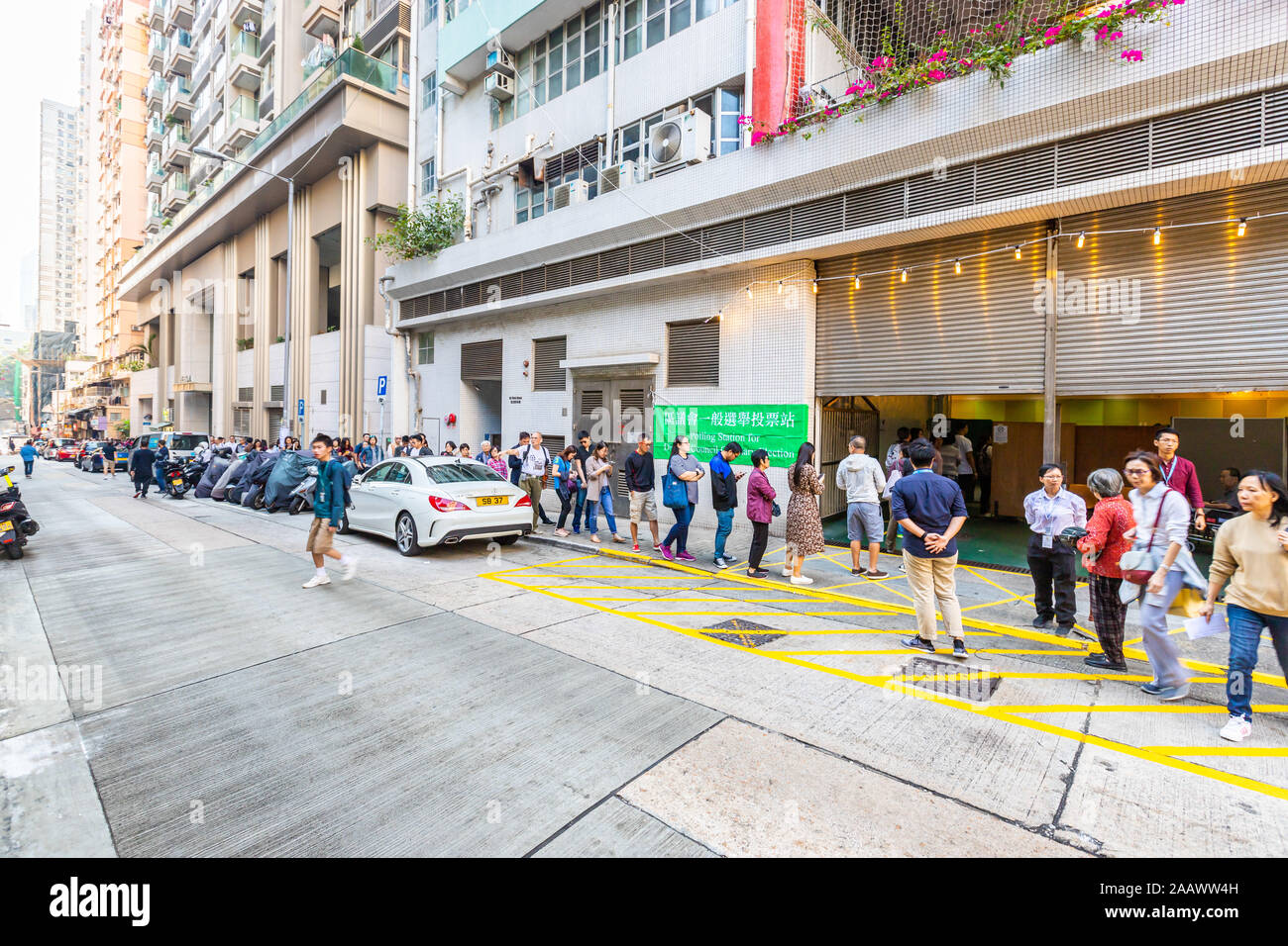 Lange Schlange vor dem Wahllokal für die 2019 Hong Kong Bezirksrat Wahlen. Hong Kong Wähler in eine Warteschlange von den Hunderten auf lokaler Wahllokale für bezirksrat Wahlen, zitieren Interessen sowohl von pro-demokratischen und pro-einrichtung Camps, die Abstimmung am Tag später gestoppt werden konnte. Vor dem Hintergrund der anhaltenden sozialen Unruhen, die die Stadt seit Juni, Hong Kong gelähmt hat erwartet, einer der größten aus der Wähler seit der Gründung der Special Administrative Region. Stockfoto