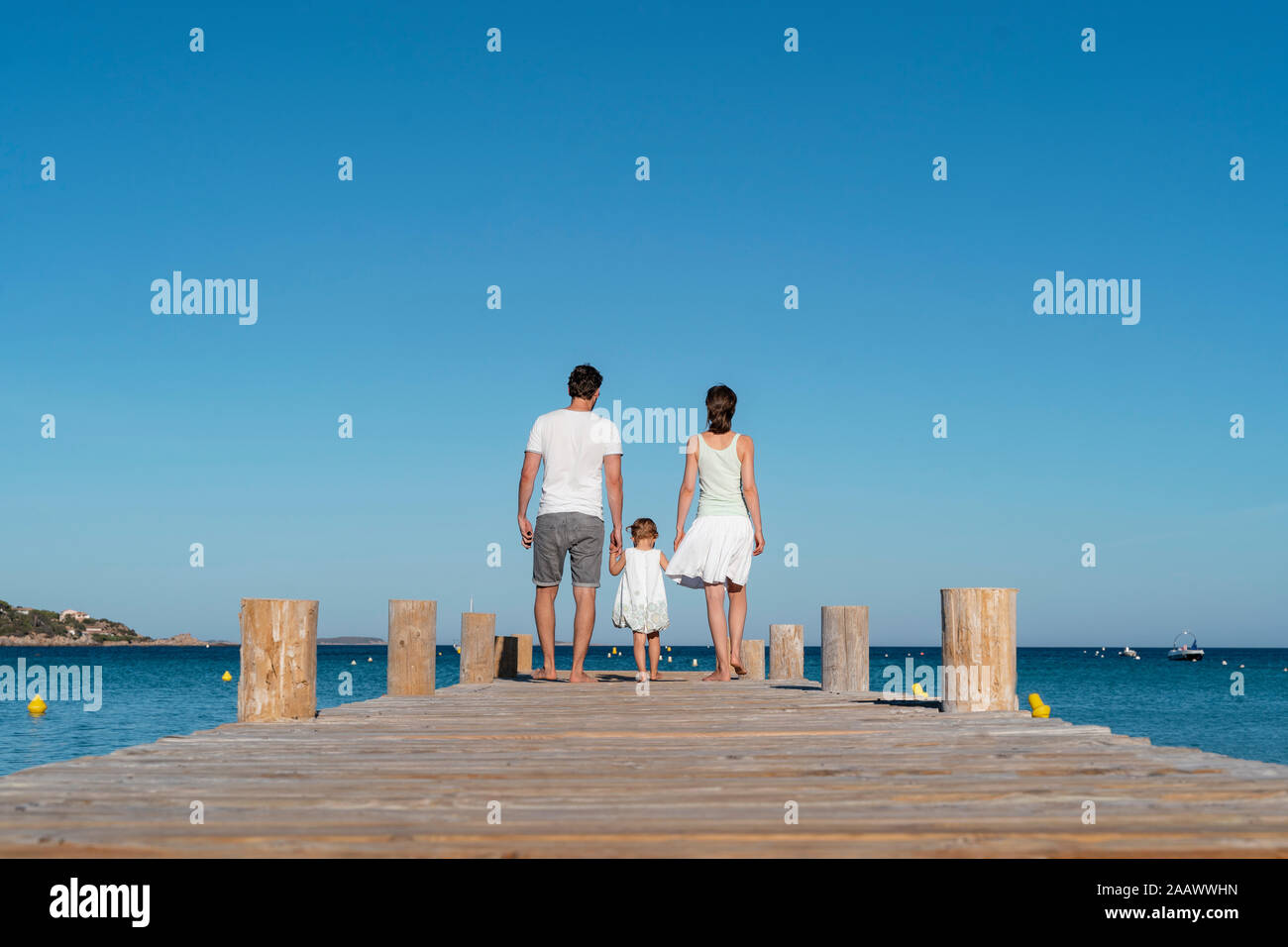 Ansicht der Rückseite des Familie zu Fuß auf einem Steg am Meer Stockfoto
