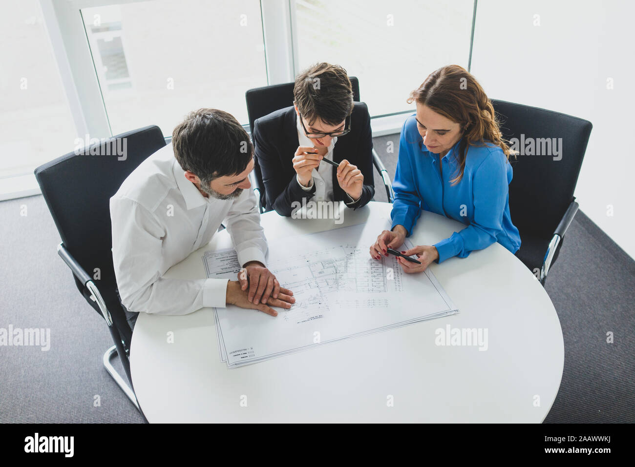 Geschäftsmann und zwei Unternehmerinnen Arbeiten am Plan auf dem Schreibtisch im Büro Stockfoto