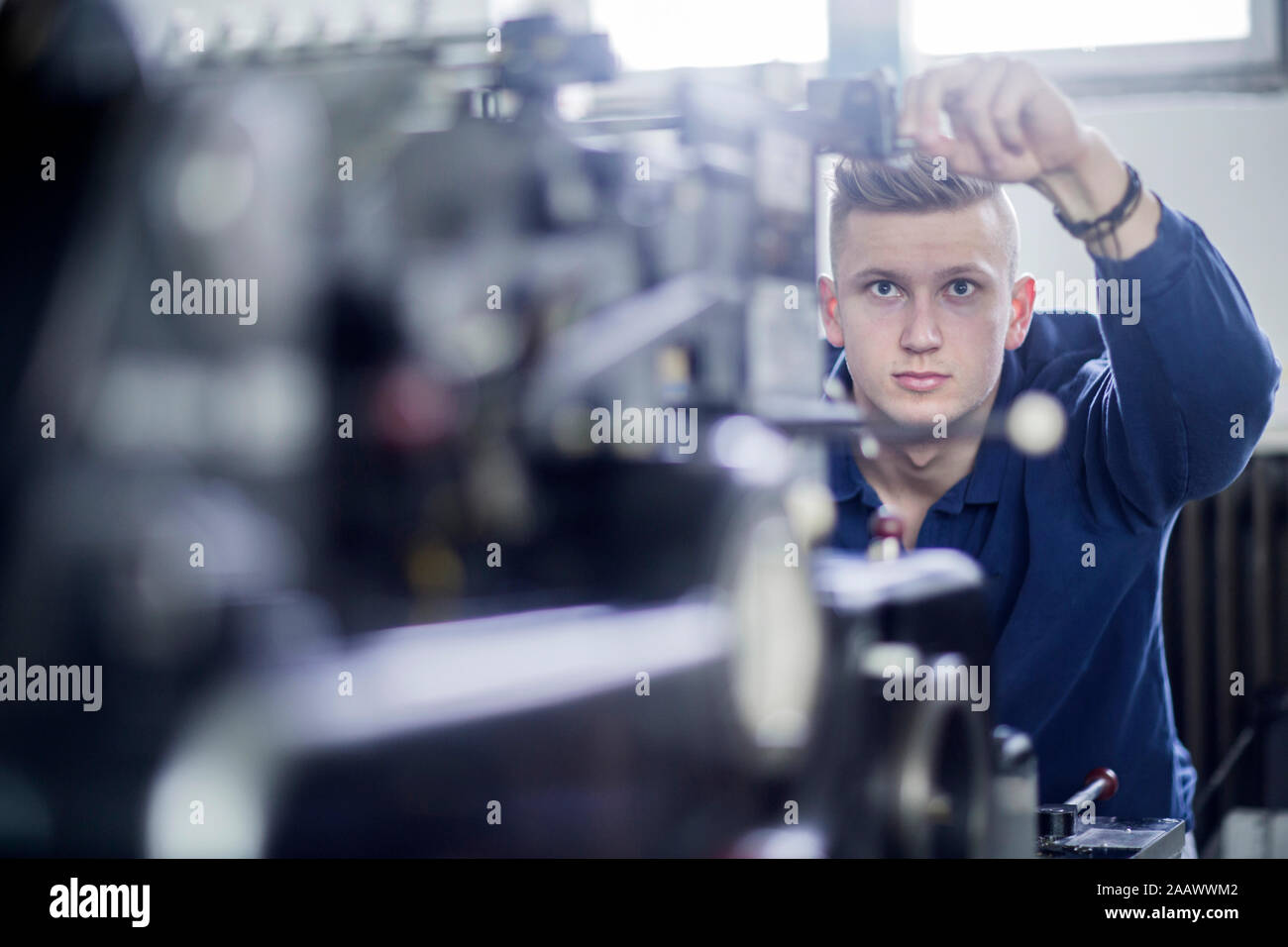 Junger Mann die Einstellung einer Maschine in einer Druckerei Stockfoto