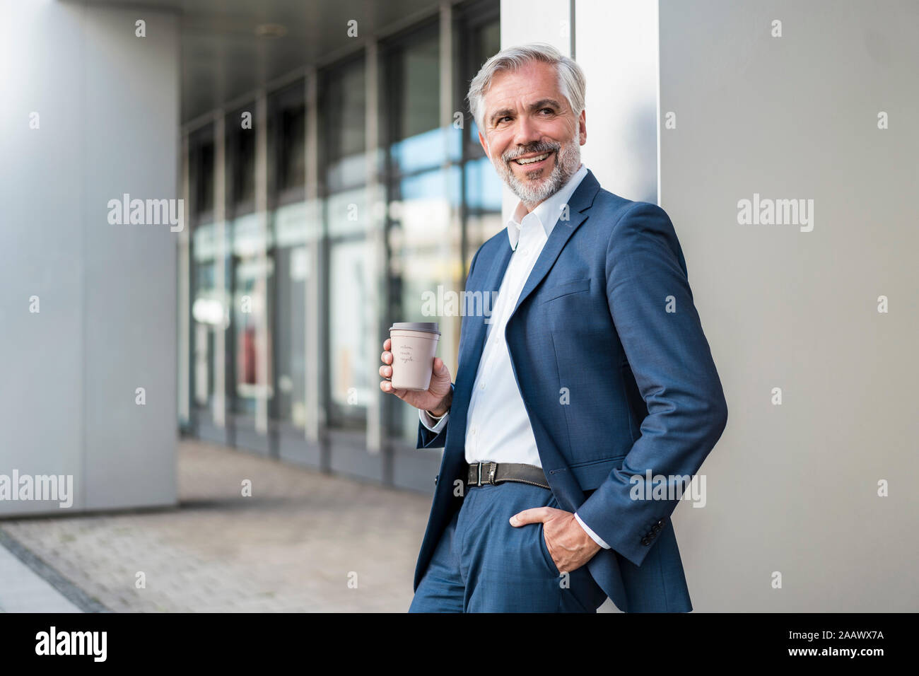 Lächelnd reife Kaufmann mit Kaffee zum Mitnehmen in der Stadt Stockfoto