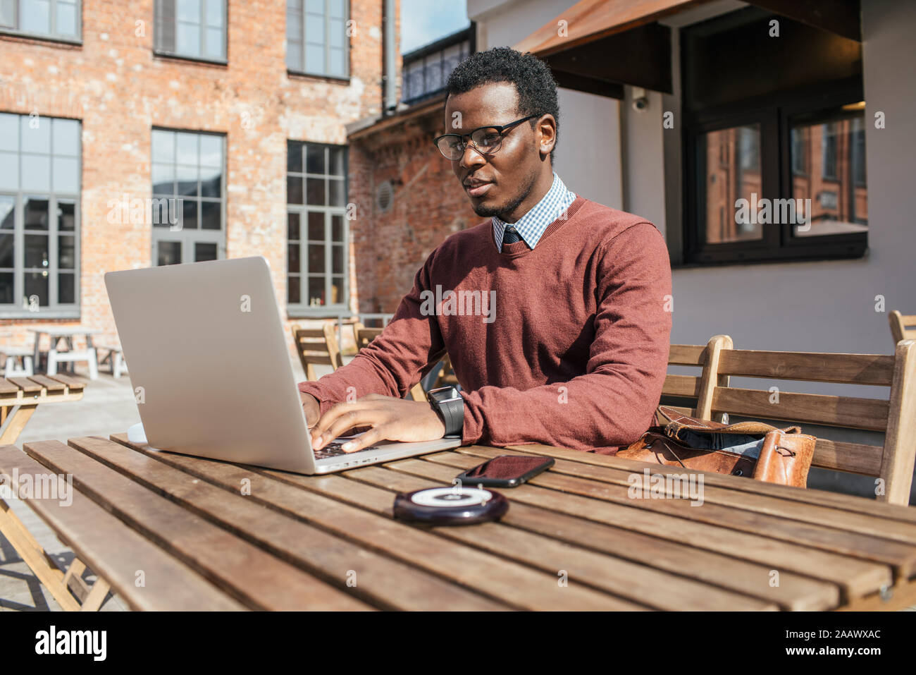 Junger Mann mit Laptop in einem Coffee Shop Stockfoto