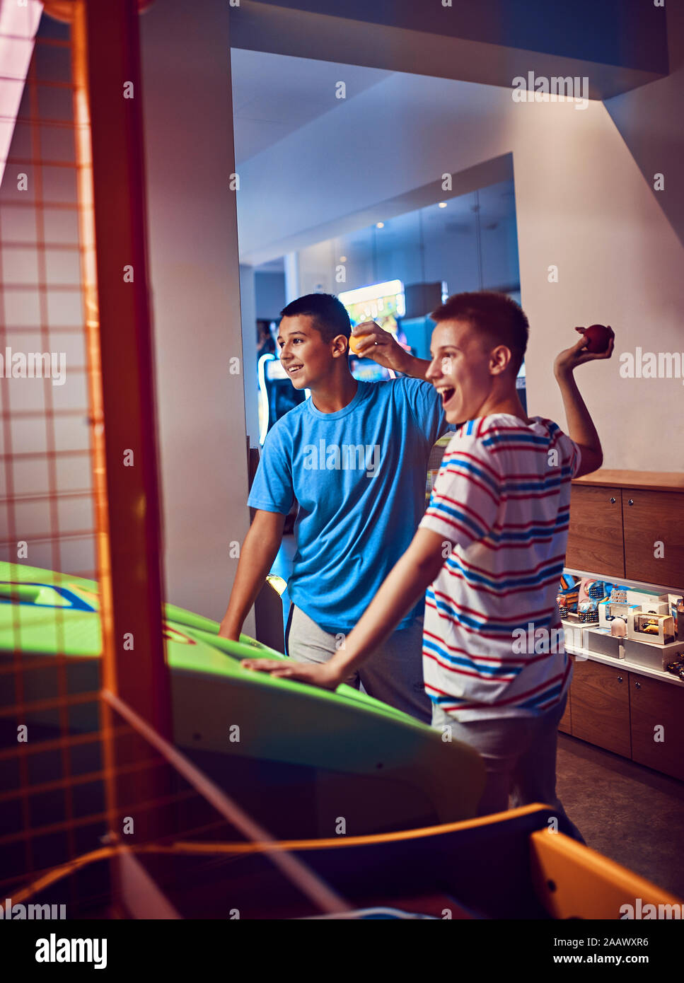 Happy teenage Freunde werfen Kugeln an einem Gaming Maschine in eine Spielhalle Stockfoto