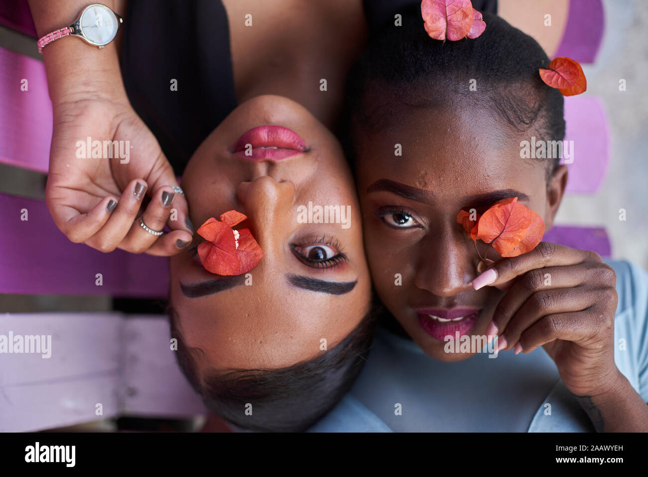 Porträt von zwei jungen Frauen, die Augen mit Blumen Stockfoto