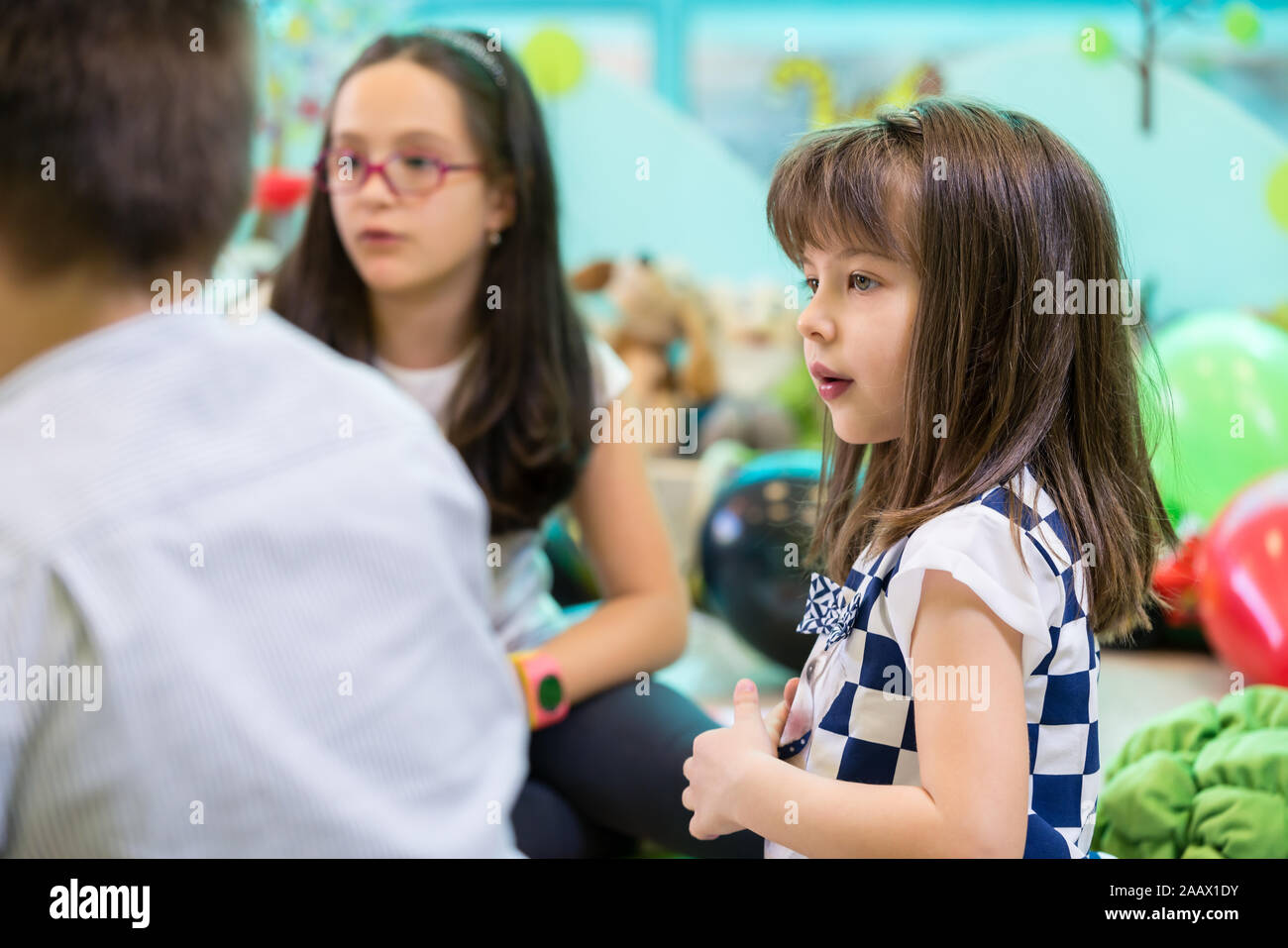 Schüchterne Mädchen an ihrer Spielkameraden Interaktion in einem modernen Kindergarten suchen Stockfoto