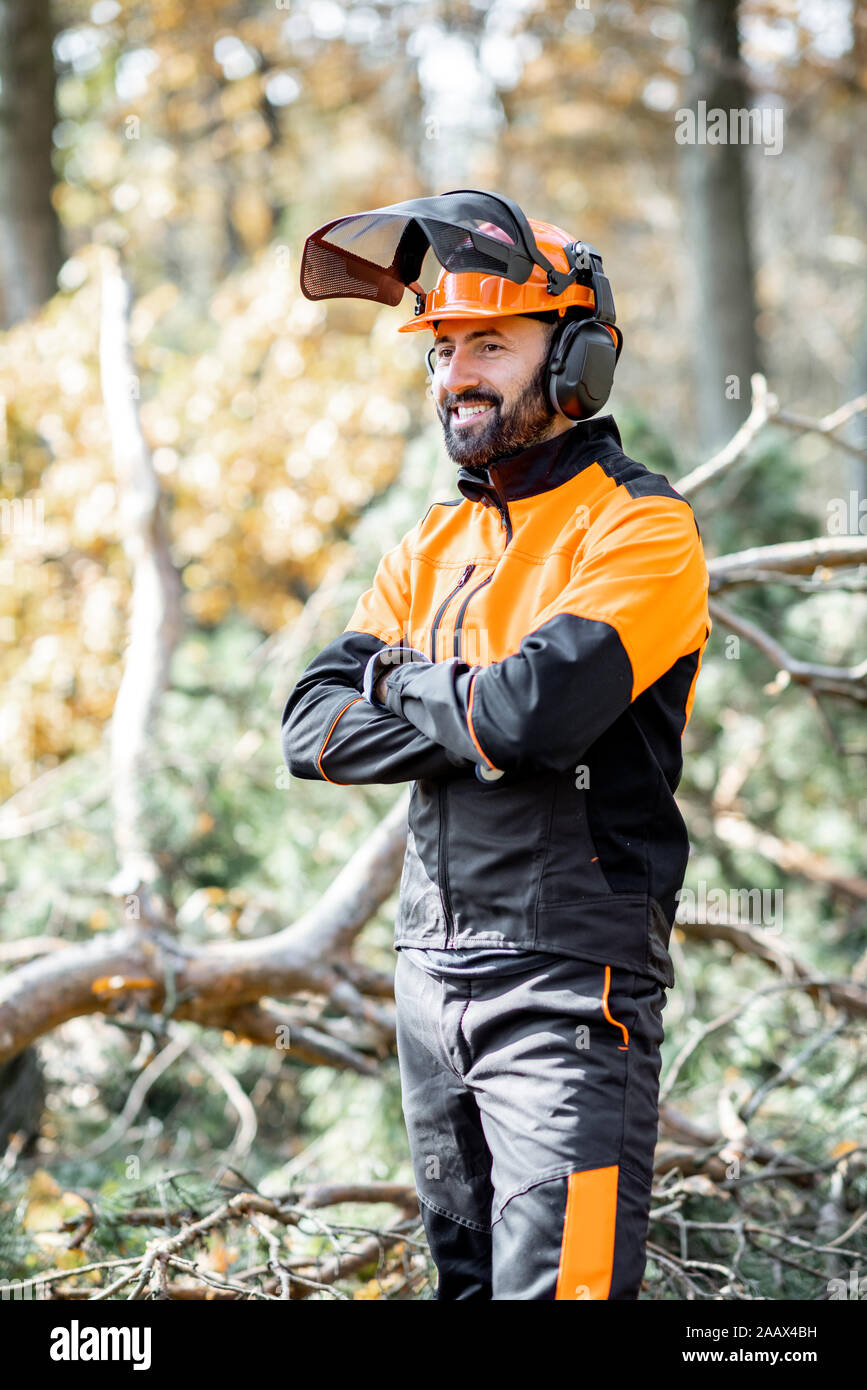 Porträt eines professionellen lumberman in harhat und schützende Arbeitskleidung stehen in den Pinienwald Stockfoto