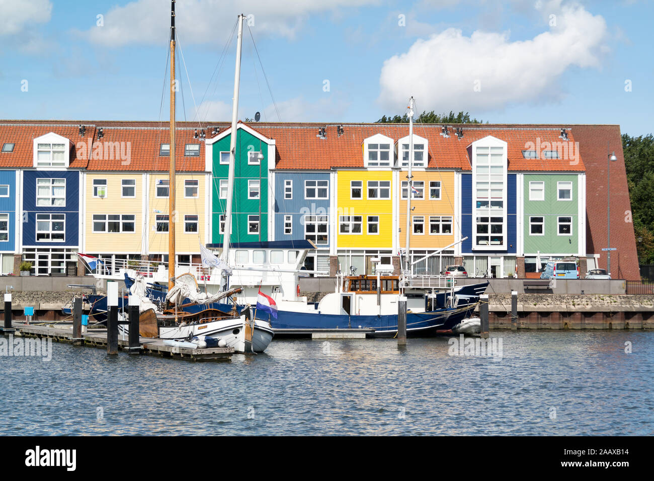 Bunte Fassaden der Wharf Häuser und Boote in der Stadt Hellevoetsluis, Niederlande Stockfoto