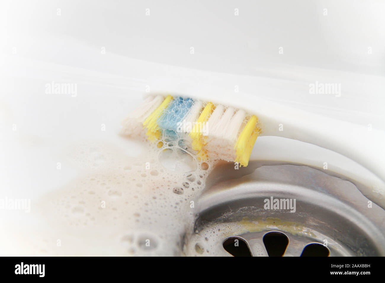 Blut und Zahnpasta auf der Zahnbürste nach dem Reinigen und Waschen der Zahnbürste. Schmerzkonzept und Gesundheit Stockfoto