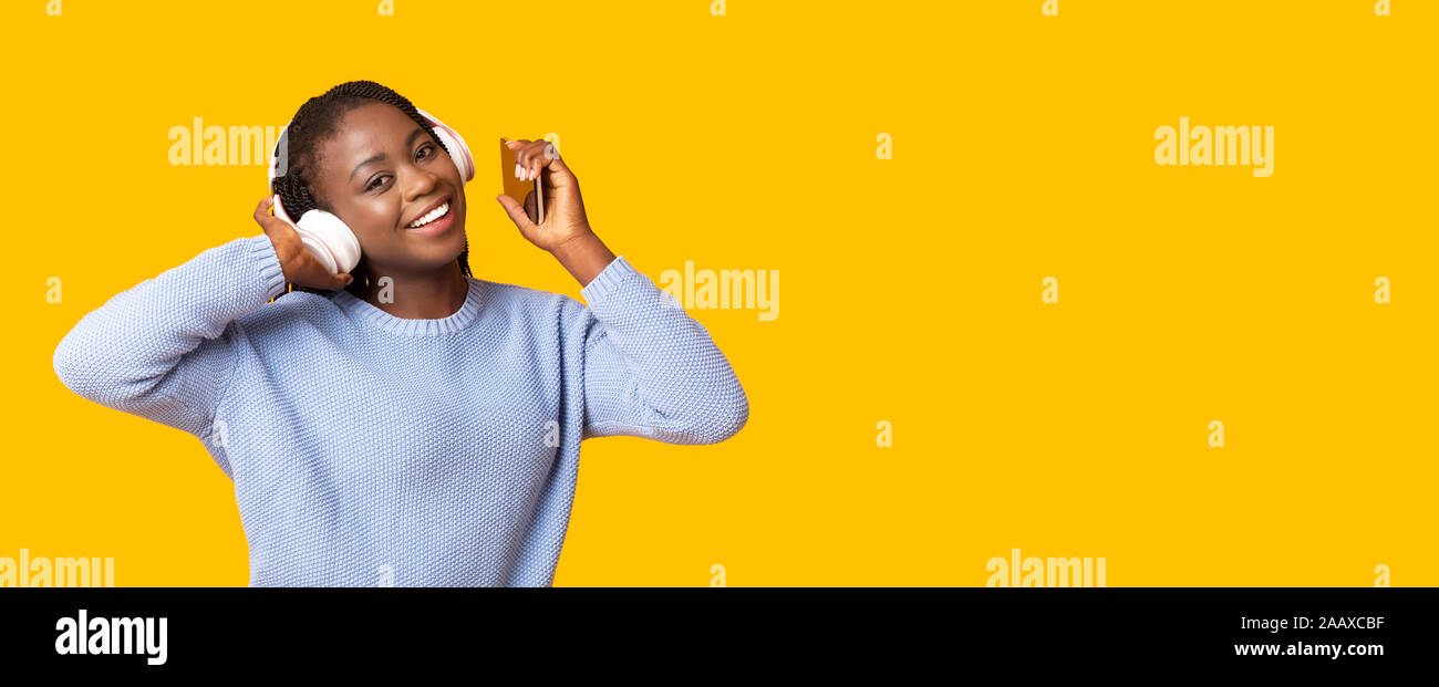 Happy afrikanisches Mädchen Musik auf gelbem Hintergrund Stockfoto