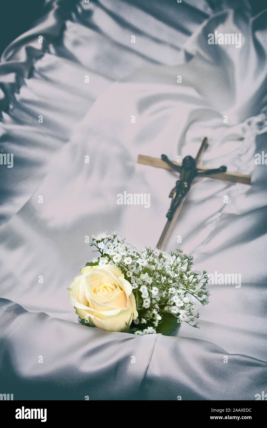 Single Rose und Religion Kreuz auf einem Sarg während einer Beerdigung Stockfoto