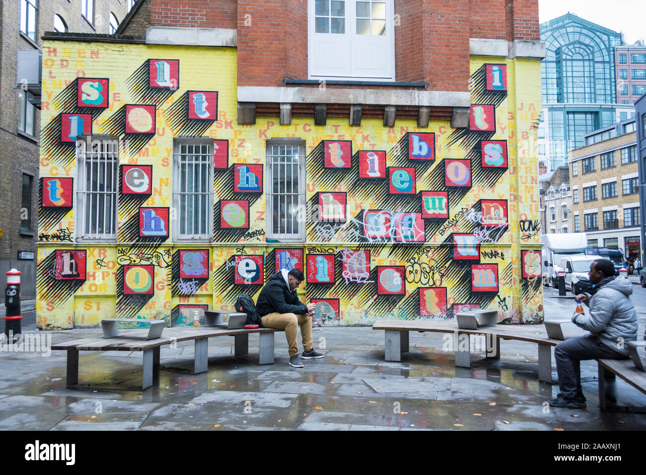 "Alphabet House' Street Art von Ben-bunte Alphabet Buchstaben auf gelbem Backstein Mauer in Spitalfields, East London, Großbritannien Stockfoto