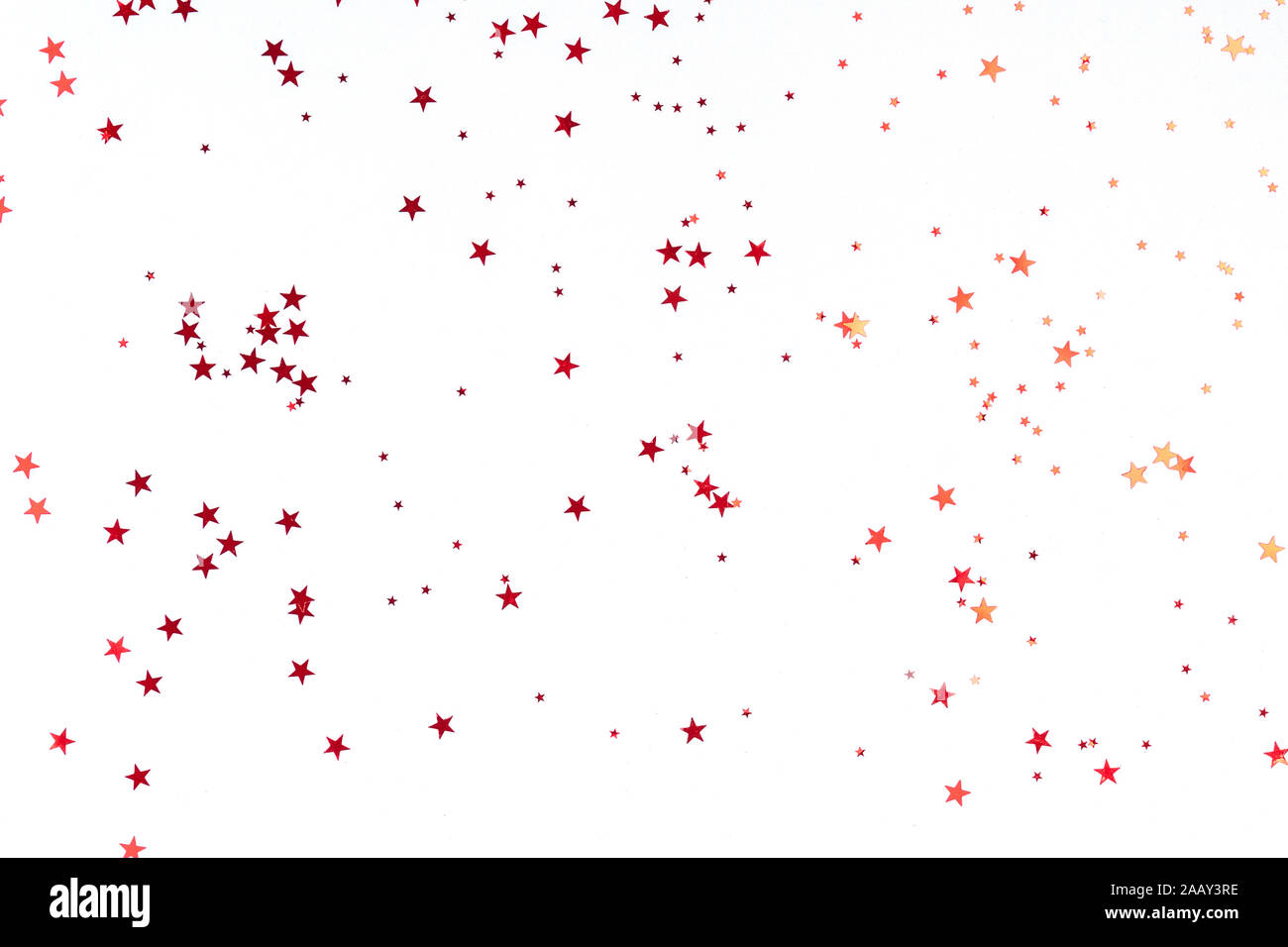 Golden Stars glitter Konfetti in abstrakten Stil auf weißem Hintergrund. Rot funkelt Textur. Urlaub neues Jahr Kulisse. Jahrestag, Geburtstag. Grußkarte Vorlage. Stockfoto