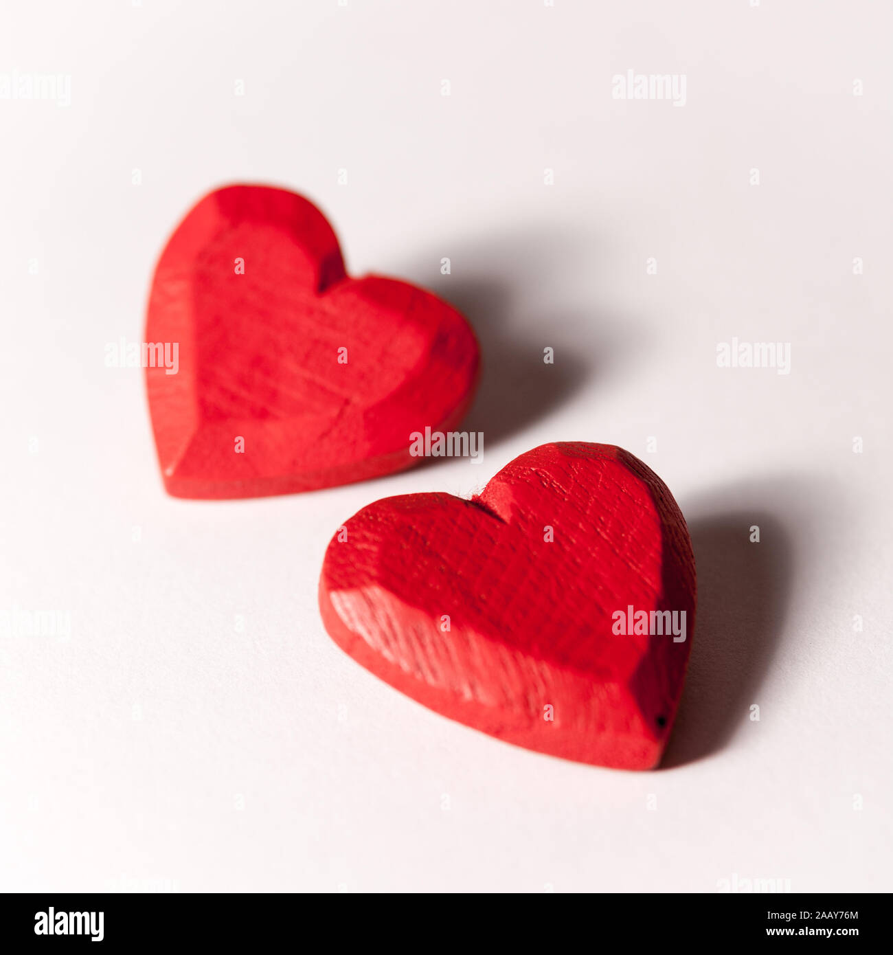 Liebe und Valentinstag: die Liebe die Herzen. Ein Paar rote aus Holz geschnitzte Herz isoliert auf Weiss. Stockfoto