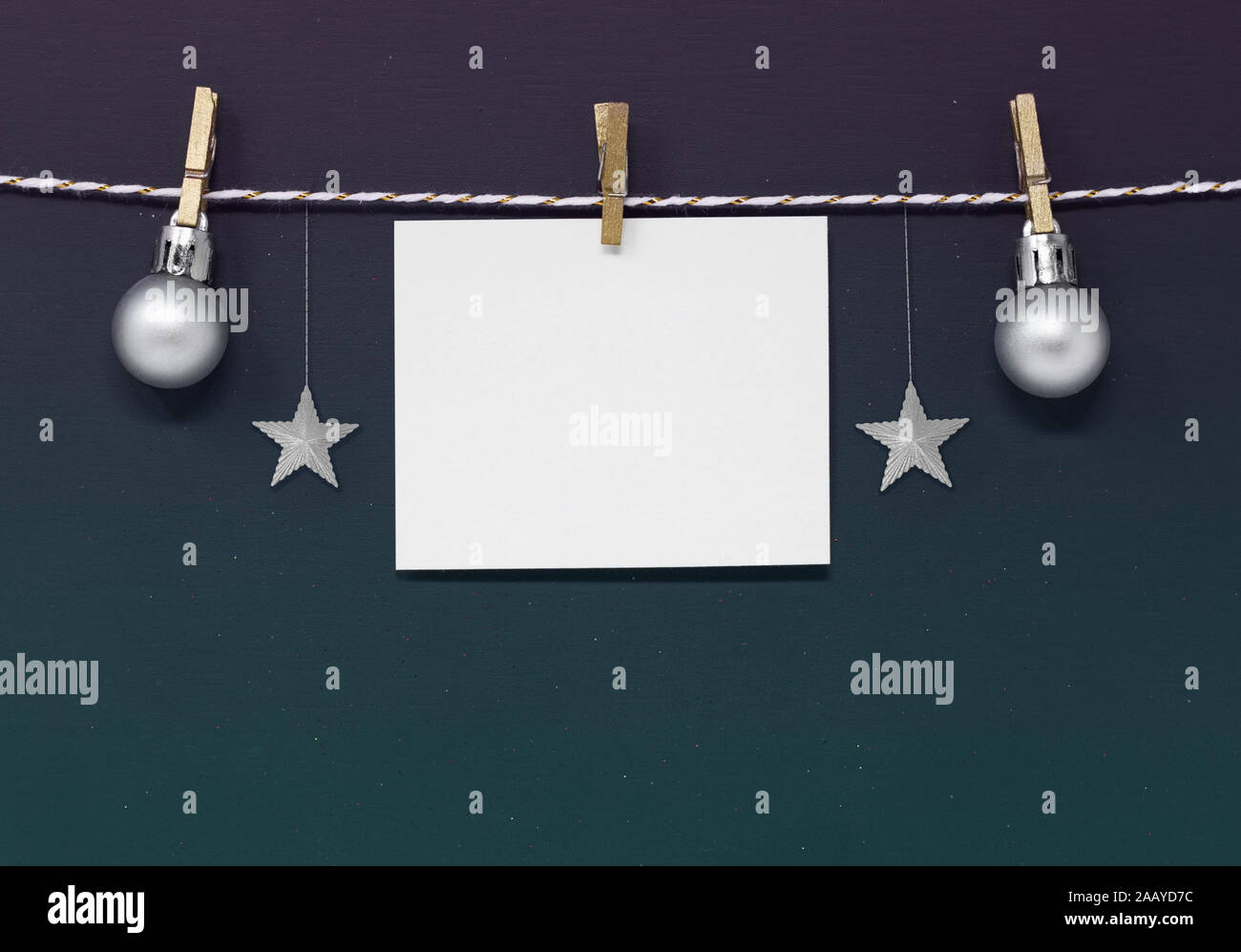 Dunkle Weihnachten Hintergrund mit leerer Hinweis Papier, Silver Stars und Christbaumkugeln hängen aus einem String. Mit kopieren. Stockfoto
