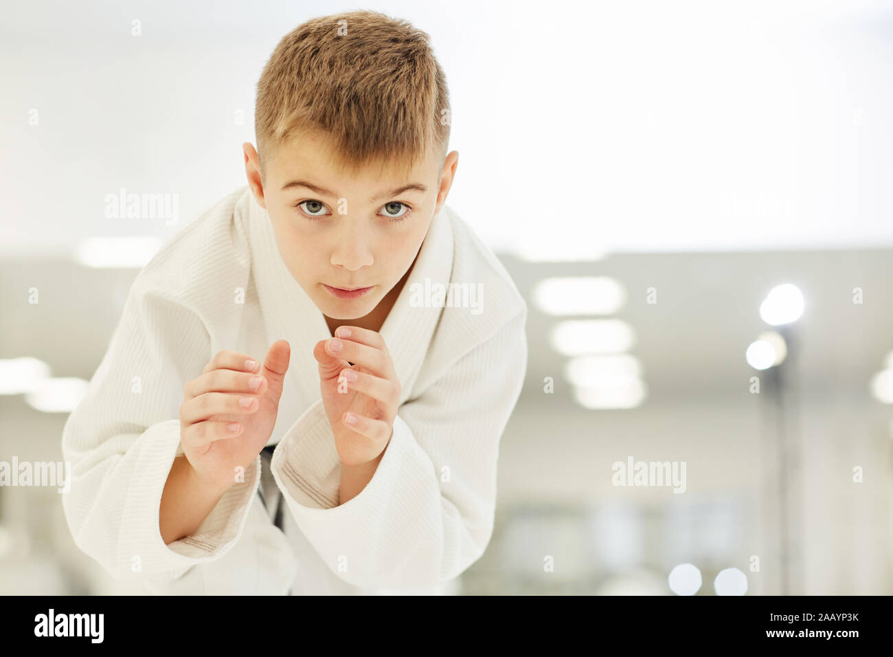 Porträt der jungen Karateka im Kimono stehen und arbeiten mit Kampftechniken im Training im Karate Stockfoto