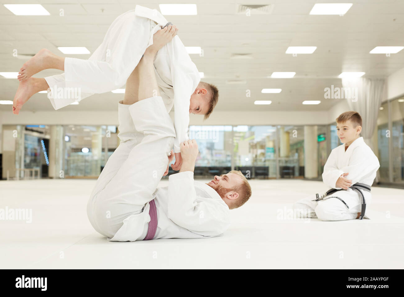 Junge Trainer zeigt Techniken der Kampf auf seine Studenten während der Ausbildung in Karate Stockfoto