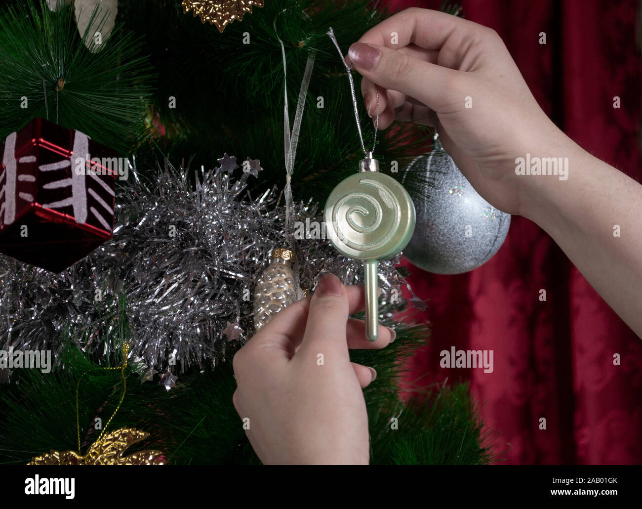 Hände schmücken Weihnachtsbaum, Foto-Illustration Stockfoto