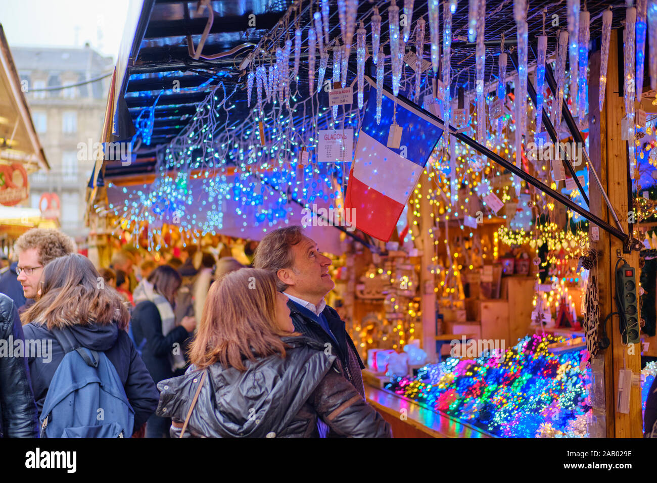 Touristen auf der Suche nach einer Anzeige von Weihnachten themed Leuchten für Verkauf in einer an die Straßburger Weihnachtsmarkt Abschaltdruck Stockfoto