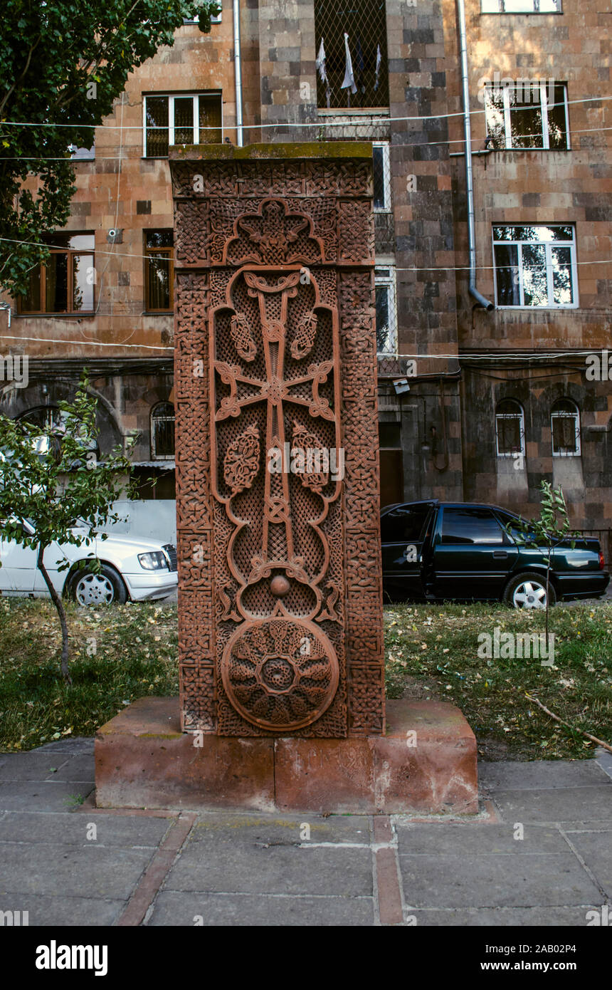 Openwork khachkar aus rotem Tuff mit einem stellte Bogen über das Kreuz und Durchbrochenem Ornament in einem Kreis auf der Gasse von Stein Kreuze in Gyumri Stockfoto