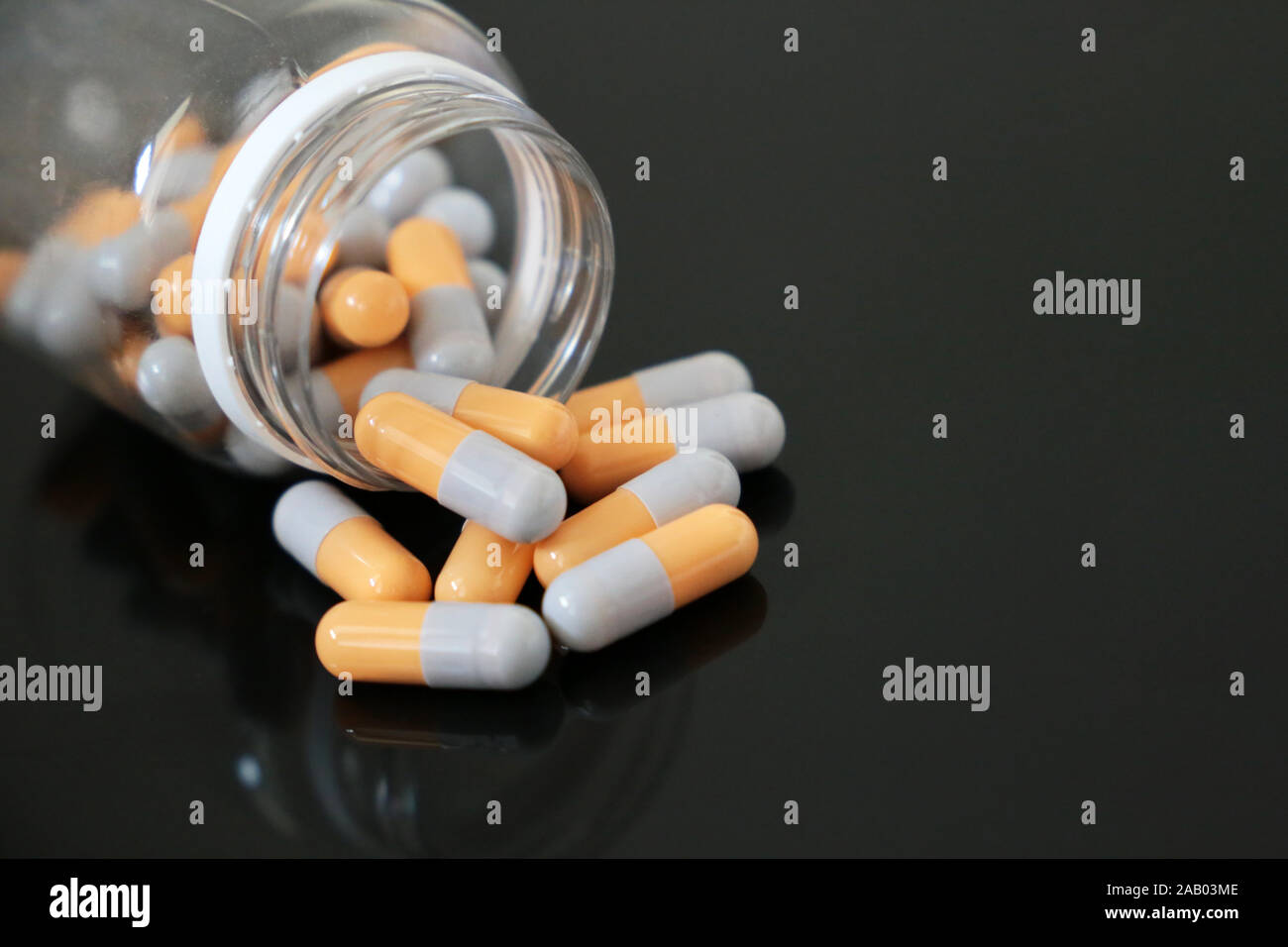 Pillen in einer Flasche, Medikation, der in Kapseln auf dunklem Glas Tisch. Konzept der Apotheke, Antibiotika, Vitamine Stockfoto