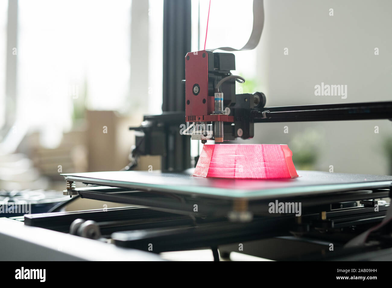 Druckkopf von 3d Drucker über Gründung der Rosa runde Objekt auf Arbeitsschicht während des Druckens Stockfoto